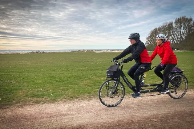 Man and woman going by bike in the sunset