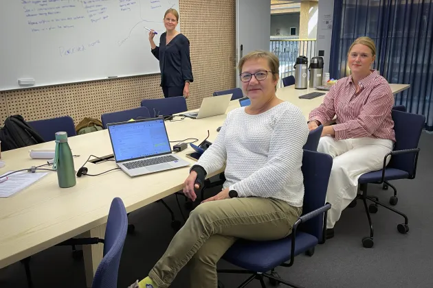 Three women around a conference table