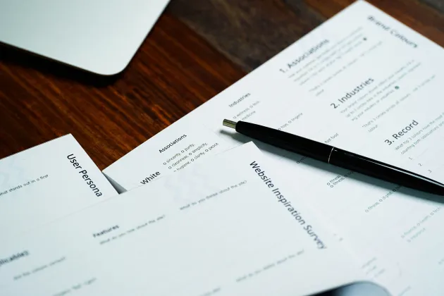 Ansökningspapper och en penna och dator