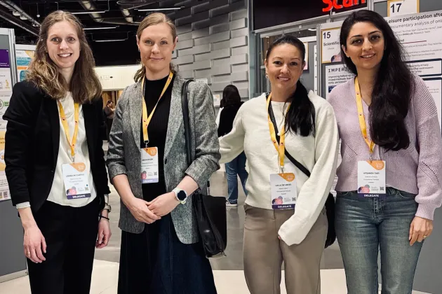 Gruppbild fyra kvinnor vid posters